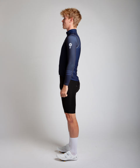 Male men’s cyclist wearing Pedalare’s high-performance navy, blue cycling vest, layered over a navy long sleeve jersey and black bib shorts. Side profile studio shot showcasing the vest’s aerodynamic fit and premium detailing. Lightweight, windproof men’s cycling vest ideal for cool weather rides. Designed by Perth cycling brand Pedalare for performance, comfort, and style. Aero cycling gear for dedicated road cyclists.