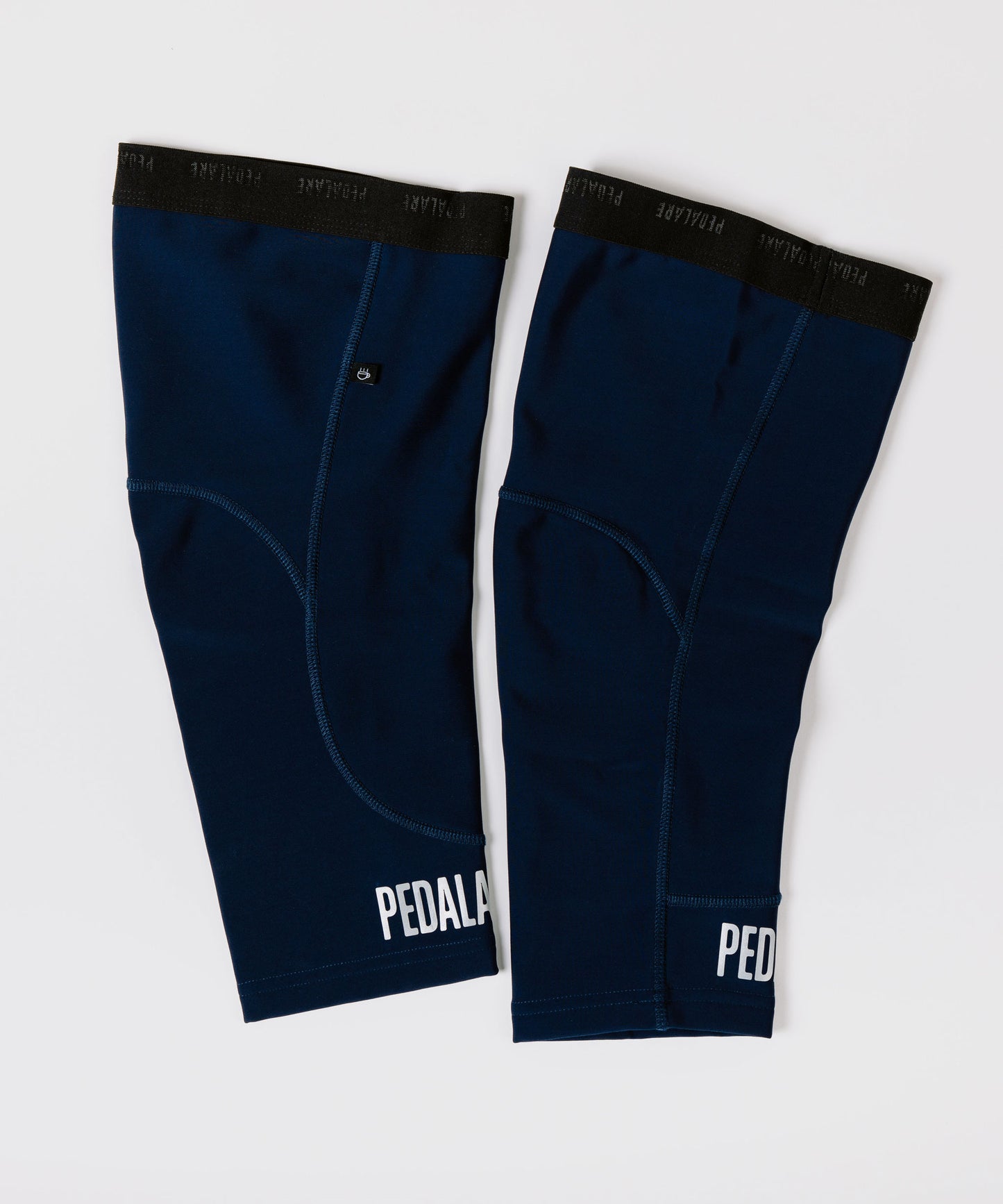 Pair of navy blue knee sleeves with 'PEDAL' branding on a white background