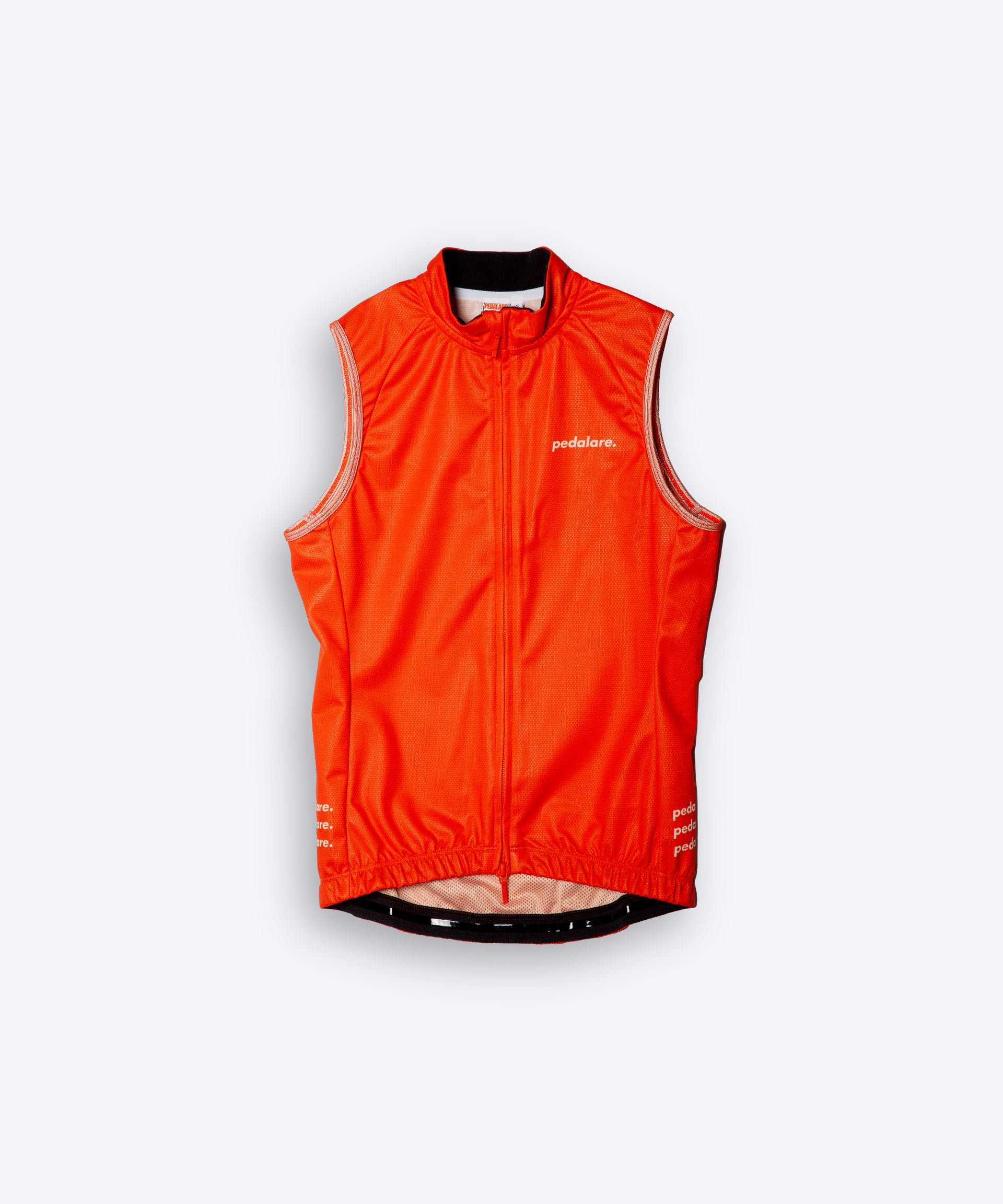 Female cyclist wearing Pedalare’s high-performance orange cycling vest, layered over a navy long sleeve jersey and black bib shorts. Side profile studio shot showcasing the vest’s aerodynamic fit and premium detailing. Lightweight, windproof men’s cycling vest ideal for cool weather rides. Designed by Perth cycling brand Pedalare for performance, comfort, and style. Aero cycling gear for dedicated road cyclists.