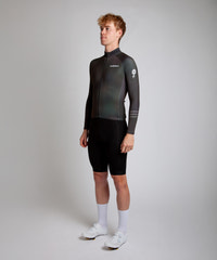 Male cyclist modelling Pedalare’s navy winter long sleeve cycling jersey, paired with black bib shorts. Side profile studio shot highlighting the jersey’s thermal fabric, streamlined fit, and subtle branding. Designed by Perth cycling brand Pedalare for cool-weather performance and style. Men’s winter cycling jersey ideal for road cyclists seeking aero cycling gear and premium cycling apparel.