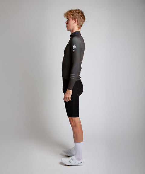 Male cyclist modelling Pedalare’s navy winter long sleeve cycling jersey, paired with black bib shorts. Side profile studio shot highlighting the jersey’s thermal fabric, streamlined fit, and subtle branding. Designed by Perth cycling brand Pedalare for cool-weather performance and style. Men’s winter cycling jersey ideal for road cyclists seeking aero cycling gear and premium cycling apparel.
