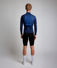 Male cyclist modelling Pedalare’s navy winter long sleeve cycling jersey, paired with black bib shorts. Side profile studio shot highlighting the jersey’s thermal fabric, streamlined fit, and subtle branding. Designed by Perth cycling brand Pedalare for cool-weather performance and style. Men’s winter cycling jersey ideal for road cyclists seeking aero cycling gear and premium cycling apparel.